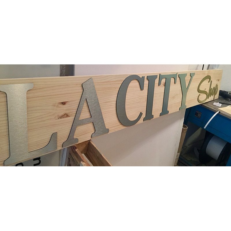 Rótulo de madera con letras metálicas para comercio.